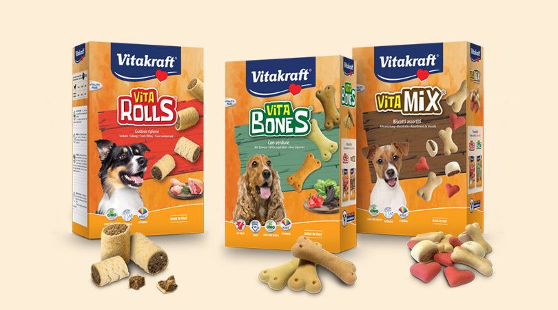 Biscotti Vitakraft AGRIAPPIA per uccelli, croccanti e colorati, mostrati su un piatto di legno con vari biscotti.