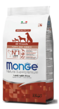 Cagnolino cucciolo di razza mista con cibo Monge Natural Superpremium All Breeds Puppy & Junior Agnello con Riso, confezione visibile